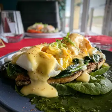 Poached eggs and hollandaise over a crispy fillet with spinach