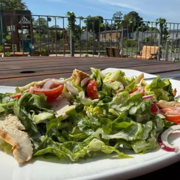 Garden salad with chicken, tomato and red onion, served on the terrace