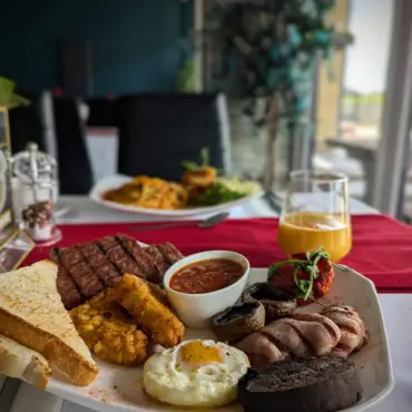 Full breakfast platter with steak, fried egg, hash browns and toast
