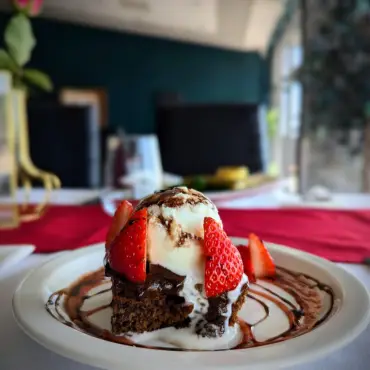Chocolate brownie with vanilla ice cream and strawberries