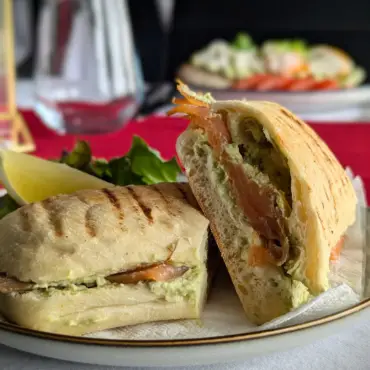 Toasted panini with smoked salmon and avocado, halved