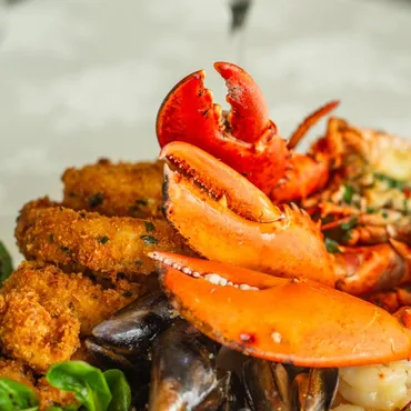 Seafood platter close-up with lobster claw, calamari and mussels