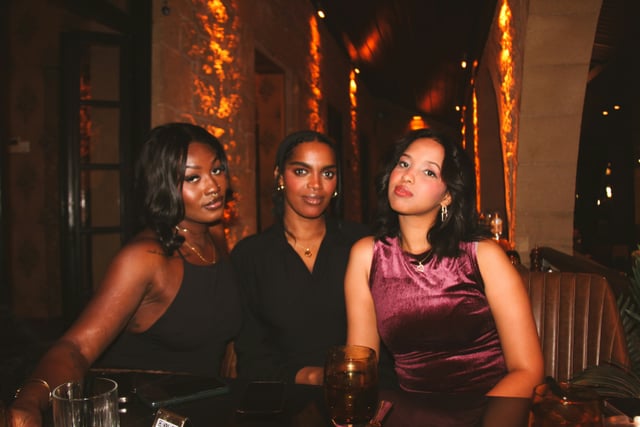 Three women enjoying a night out at a restaurant table